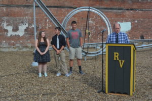 Tony Bible addresses the crowd at the ribbon cutting for the roller coaster Art Connects project completed by students from River View High School. Joining him for the event were Sydney Minton, Jayden Kelley and Cale Bible. Josie Sellers | Beacon