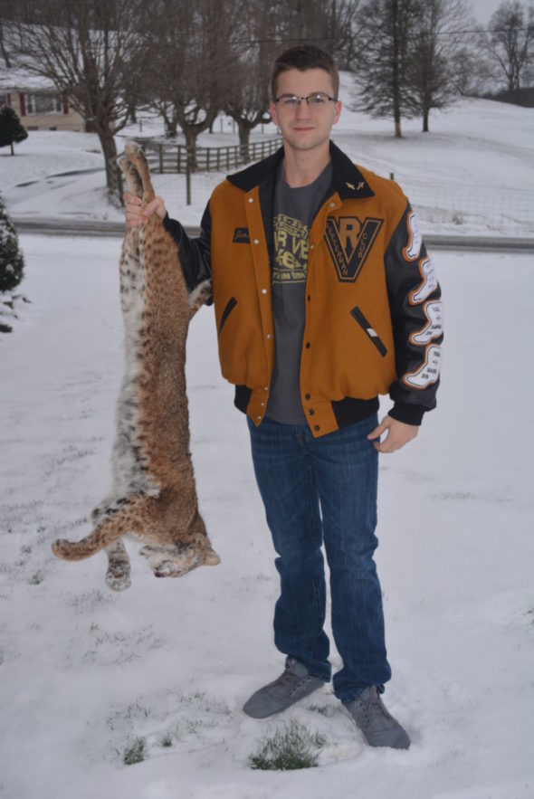 Jordan Olinger is pictured holding up a dead bobcat that was found on his family’s property on County Road 23. Josie Sellers | Beacon